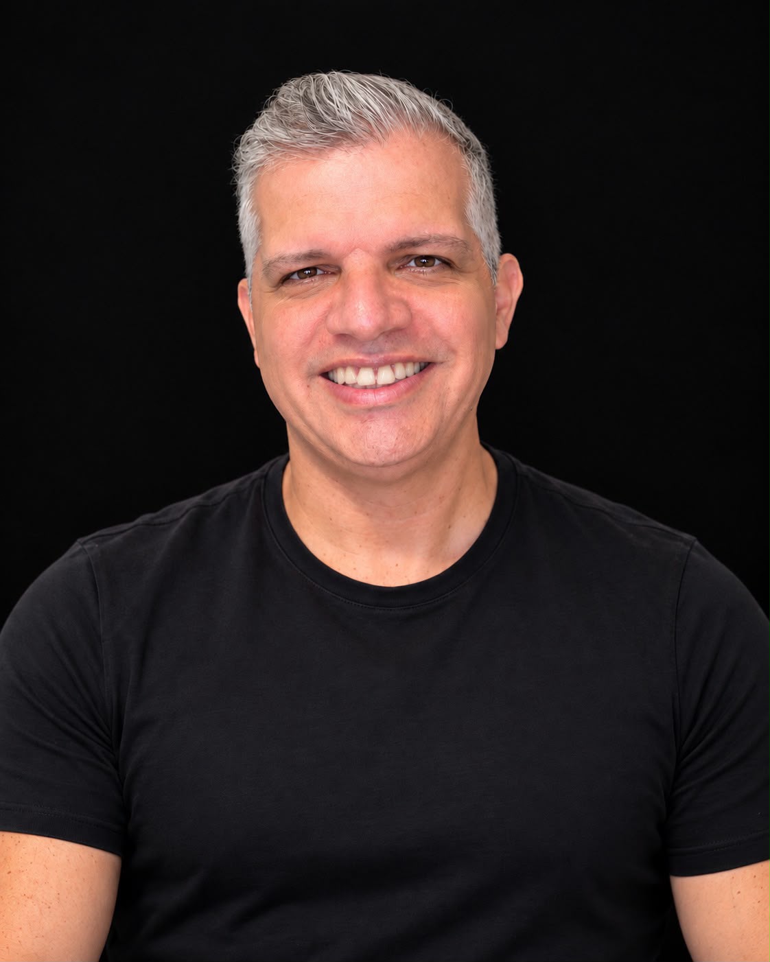 Retrato de Cristiano Abreu Paiva sorrindo, usando camiseta preta
